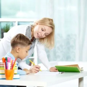 A woman helping a boy with homework