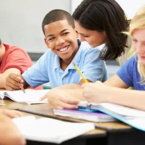 A group of students sitting at a table with papers.