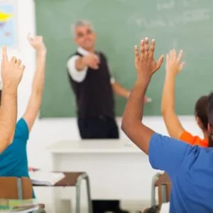 A group of people sitting in front of a chalkboard.
