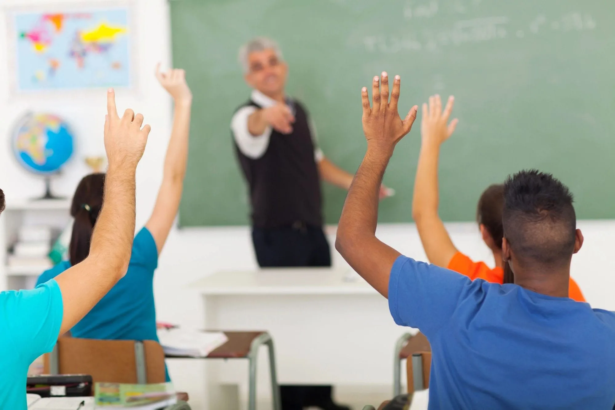 A group of people sitting in front of a chalkboard.