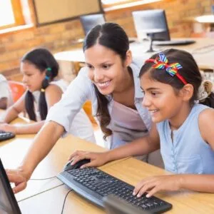 A woman and two girls are using computers.